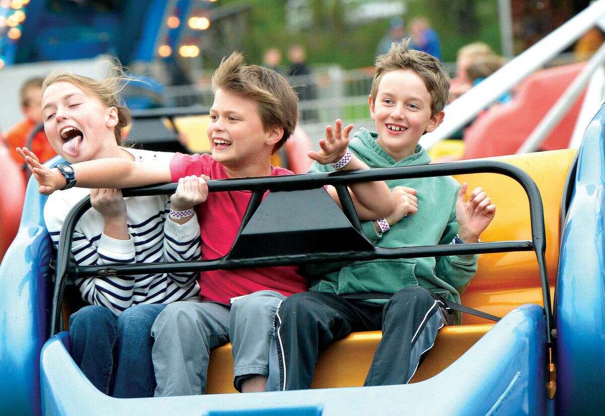 Hour Photo/Alex von Kleydorff Phoebe Naylor , Henry Naylor and Alexander Fortuna take a ride on the scrambler during opening night at the Rowayton Carnival