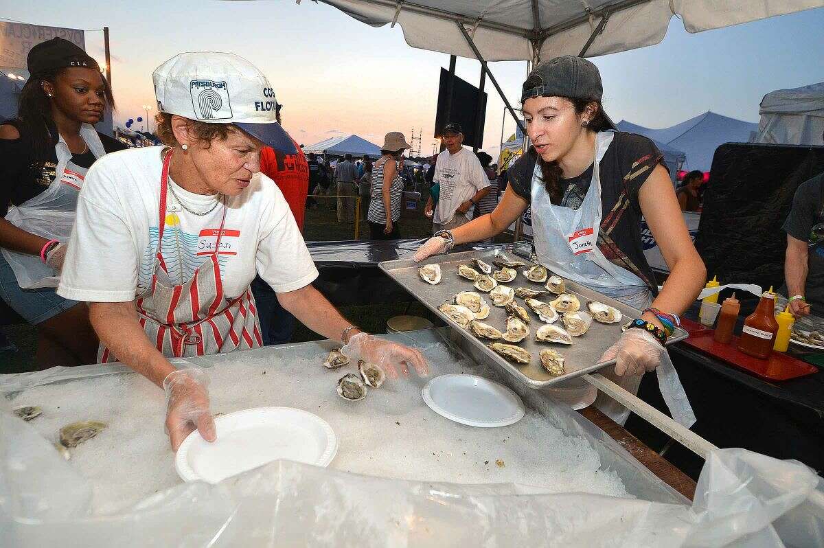 Hour Photo/Alex von Kleydorff Susan Slama and Jonette Colletti get more fresh oysters ready for the crowd at the Flotilla 72 tent at The Norwalk Seaport association Oyster Festival on Friday night