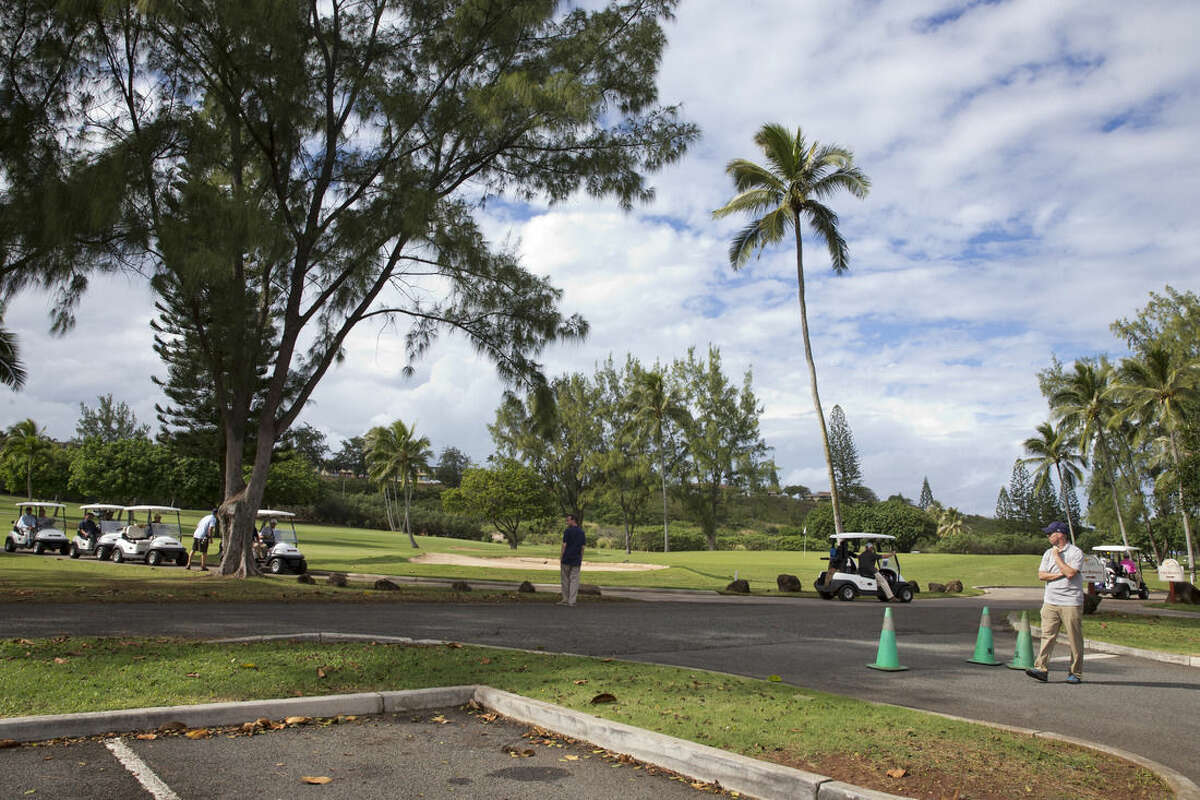 FILE -In this Dec. 24, 2014 file photo, President Barack Obama drives away from the 18th hole in a golf cart, far right, with Malaysian Prime Minister Najib Razak as they play golf at Marine Corps Base Hawaii's Kaneohe Klipper Golf Course in Kaneohe, Hawaii. A couple getting married near President Barack Obama’s vacation spot in Hawaii learned the hard way that the big day rarely goes exactly as planned. The bride and groom _ both U.S. Army captains _ were scheduled to tie the knot Sunday at Kaneohe Klipper Golf Course, a military course with ocean views near Obama’s rented vacation home in Kailua. But on Saturday, they were told they’d have to move their wedding away from the 16th hole because Obama and his friends planned to golf.(AP Photo/Jacquelyn Martin, File)