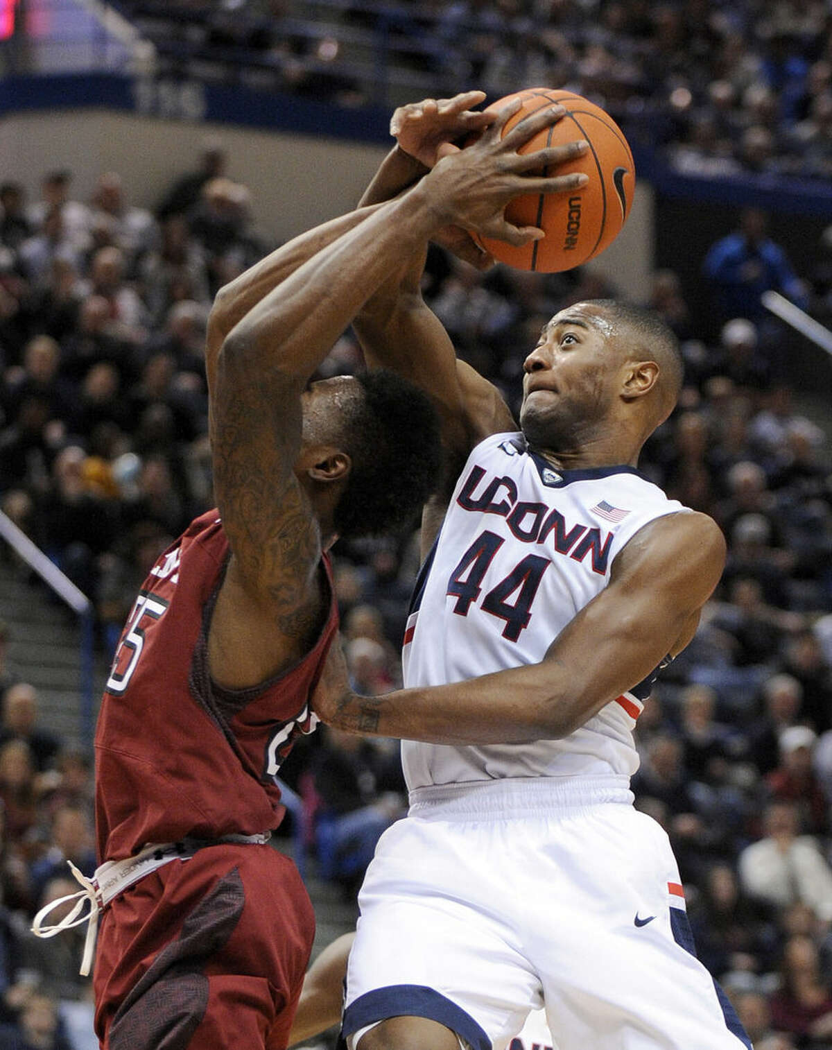 Connecticut's Rodney Purvis (44) fouls Temple's Quenton DeCosey (25) during the first half of an NCAA college basketball game in Hartford, Conn., on Wednesday, Dec. 31, 2014. (AP Photo/Fred Beckham)