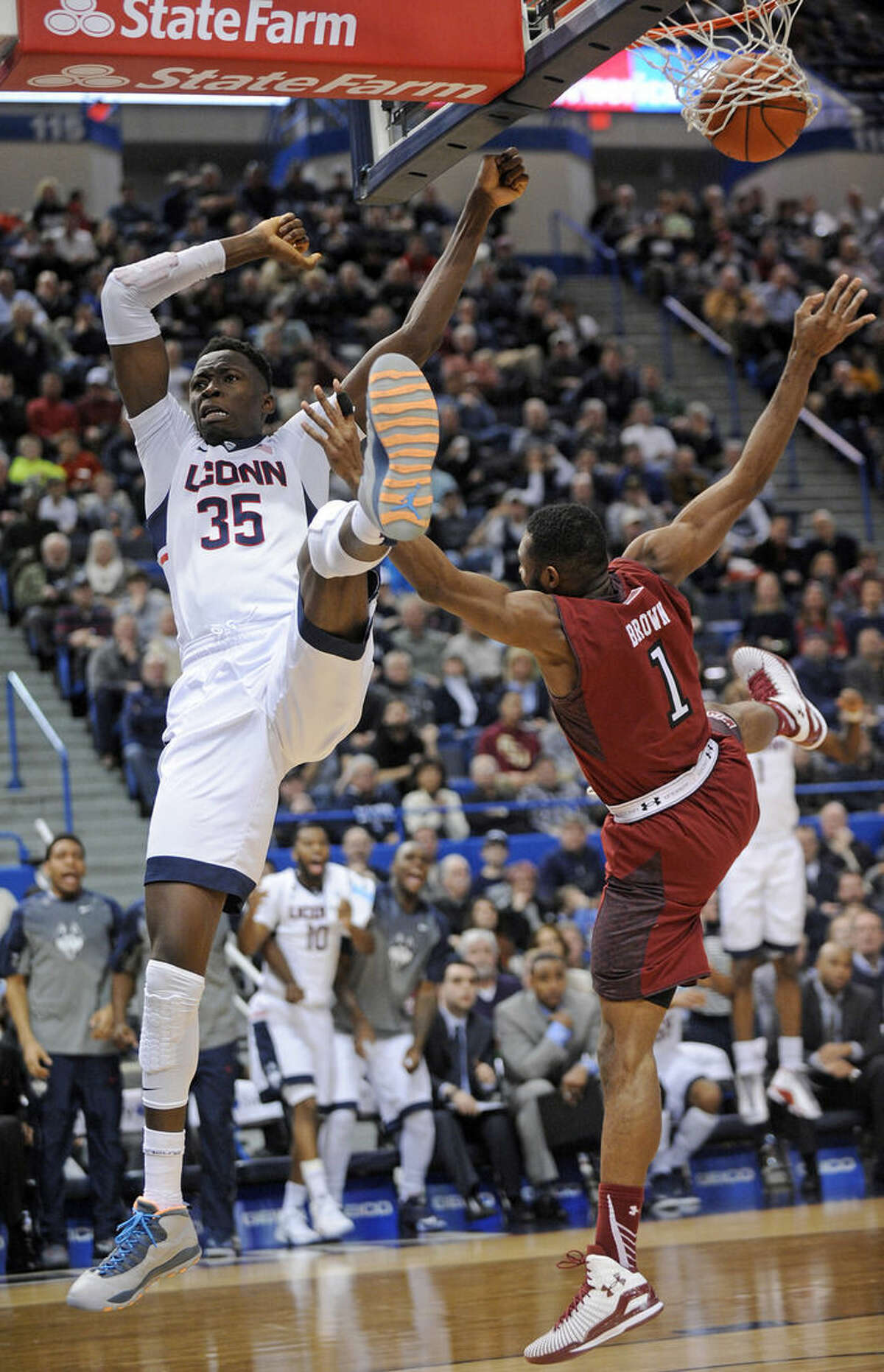 Connecticut's Amida Brimah (35) is fouled by Temple's Josh Brown (1) late in the second half of Temple's 57-53 overtime victory in an NCAA college basketball game in Hartford, Conn., Wednesday, Dec. 31, 2014. (AP Photo/Fred Beckham)