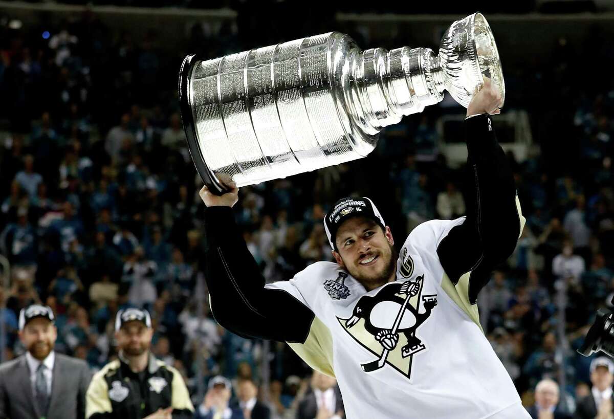 SAN JOSE, CA - JUNE 12: Sidney Crosby #87 of the Pittsburgh Penguins celebrates by hoisting the Stanley Cup after their 3-1 victory to win the Stanley Cup against the San Jose Sharks in Game Six of the 2016 NHL Stanley Cup Final at SAP Center on June 12, 2016 in San Jose, California.