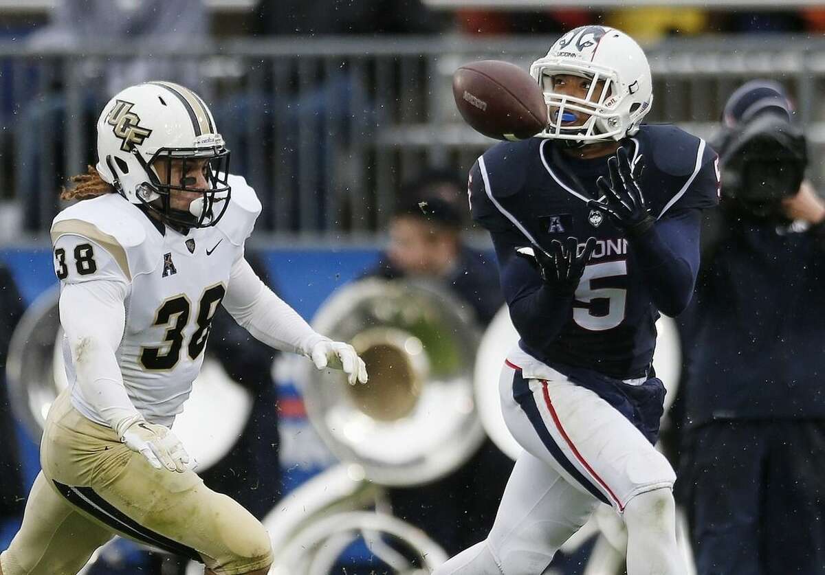 Connecticut wide receiver Noel Thomas (5) makes a touchdown reception in front of Central Florida defensive back Jordan Ozerities (38) during the second quarter of an NCAA college football game in East Hartford, Conn., Saturday, Nov. 1, 2014. (AP Photo/Michael Dwyer)