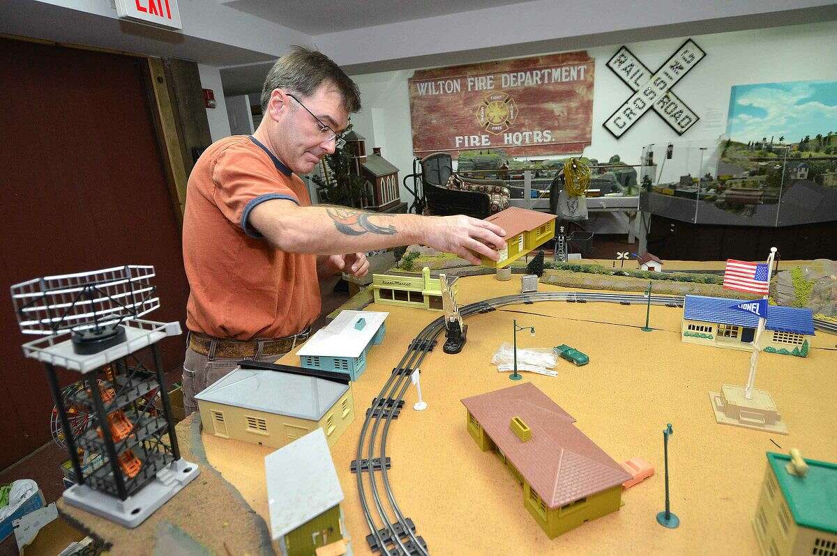 Richard Fuhrman places a ranch house from the 1950s into the Great Trains exhibit at the Wilton Historical Society.