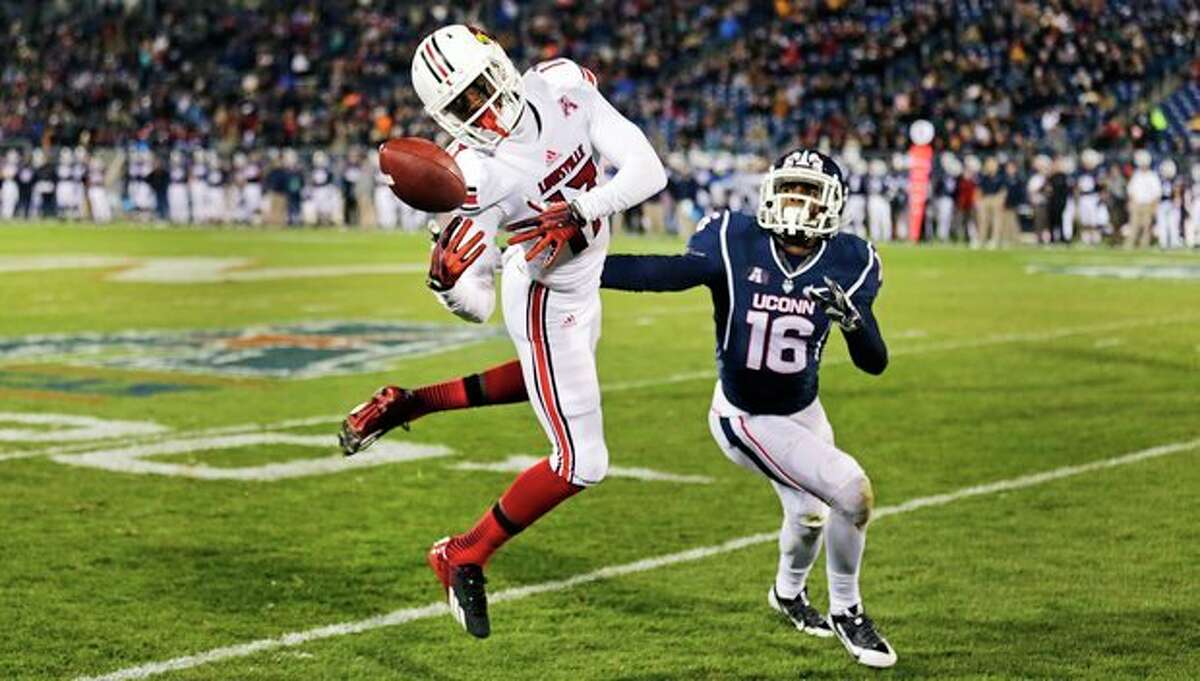 Louisville wide receiver James Quick (17) attempts to get a grip on the ball as Connecticut's Byron Jones (16) defends during the first half of an NCAA college football game, in East Hartford, Conn., Friday, Nov. 8, 2013. (AP Photo/Charles Krupa)