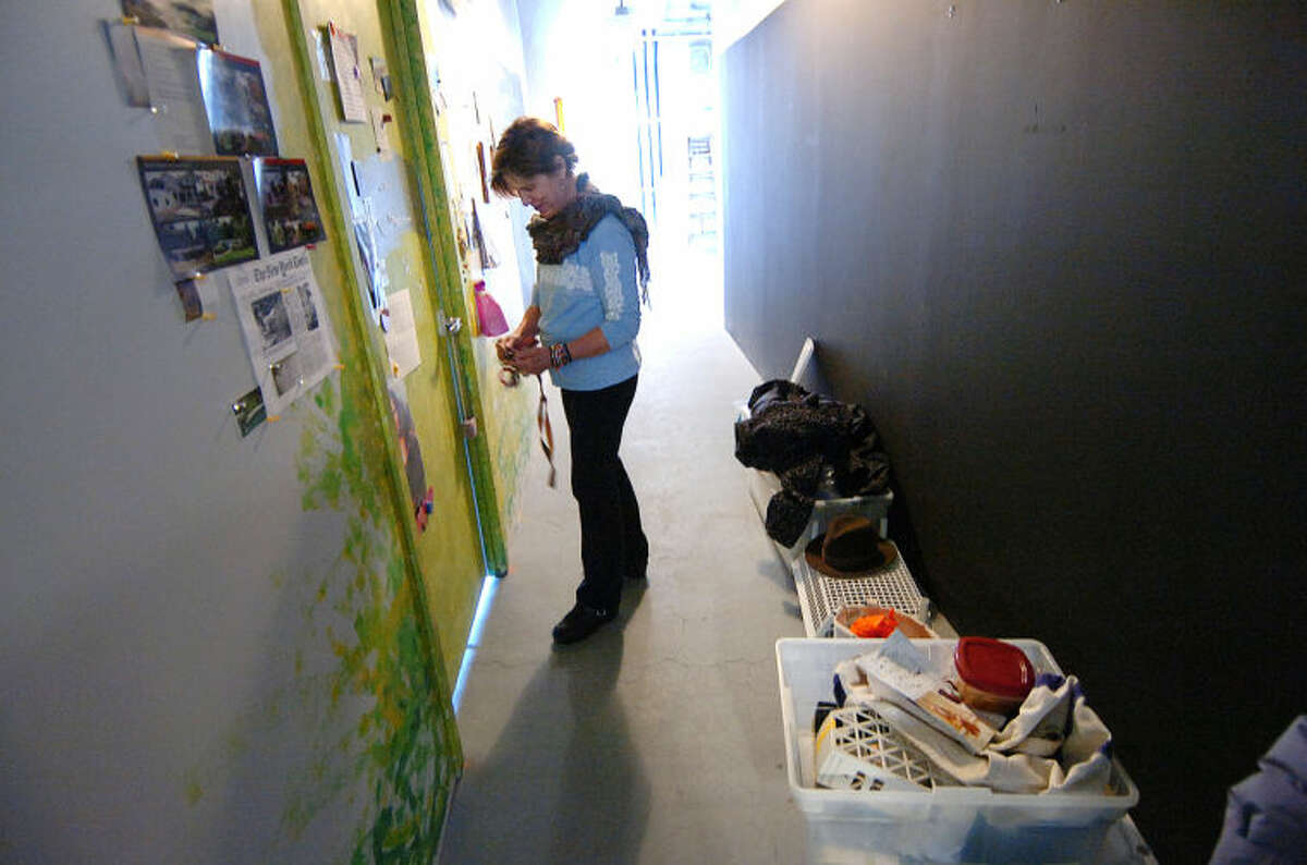 Artist Wendi Ohlson unlocks the door to her studio of five years, while items have been placed in the hallway as she organizes and packs for a potential move from the Loft Artist Association Studios and Gallery in Stamford.