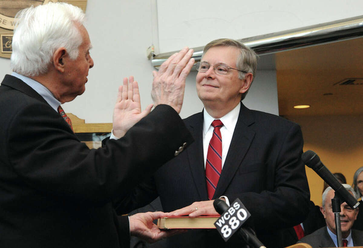 Hour photo / Matthew Vinci David Martin takes the oath of office from his father, Judge Gene Martin, on Dec. 2, 2013 during a ceremony at the Stamford Government Center that was attended by hundreds of his friends and supporters.