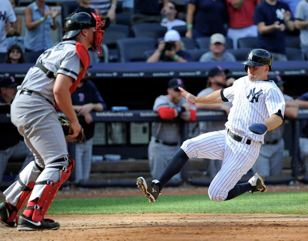 New York Yankees' Brett Gardner scores on a double by Mark Reynolds (not shown) as Boston Red Sox catcher Ryan Lavarnway, left, waits for the ball during the eighth inning of a baseball game Saturday, Sept. 7, 2013, at Yankee Stadium in New York. (AP Photo/Bill Kostroun)