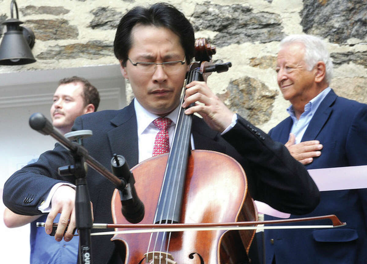 Hour photo/Matthew Vinci Kenneth Kuo, President/CEO of Rental instrument, LLC plays the National Anthem on his cello Sunday at the new loction in Norwalk for his instrument rental company.