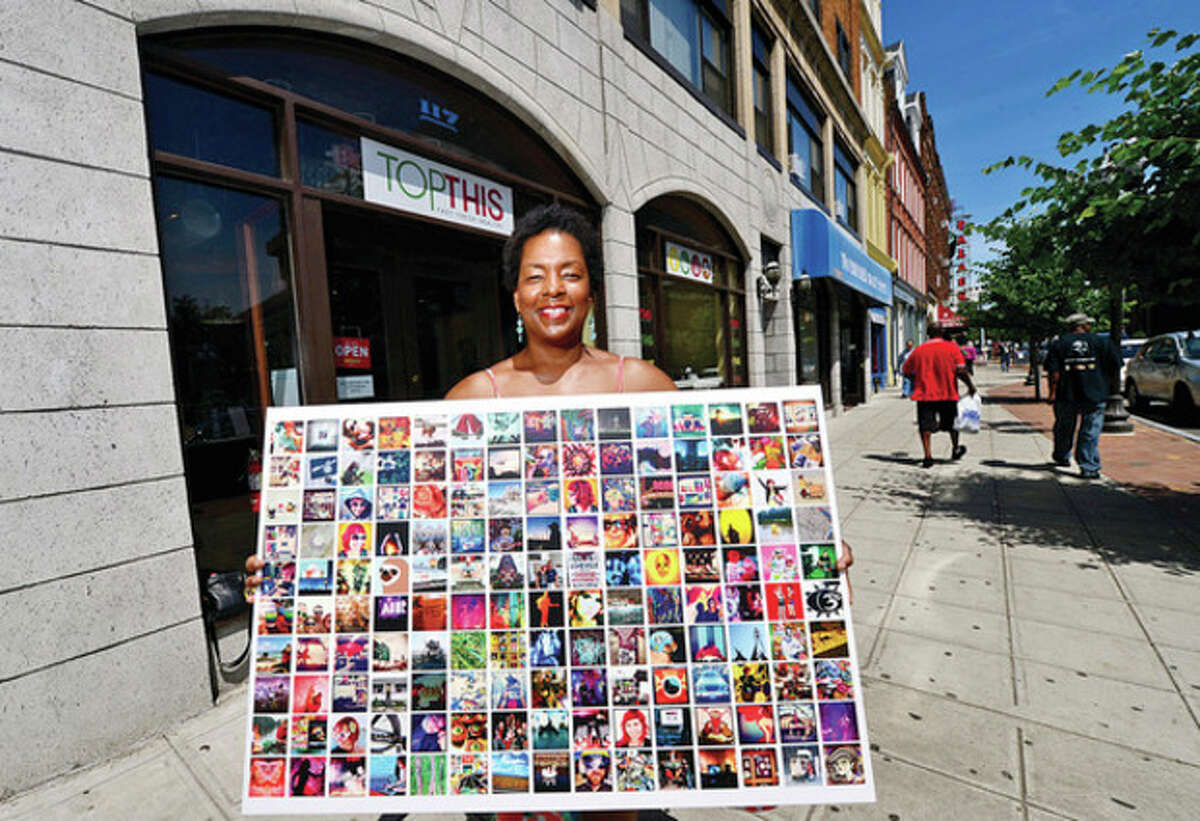 Hour photo / Erik Trautmann Valerie Cooper, curator of upcoming ARTWALK in Stamford, displays some of the artwork to be exhibited on next weekend's ARTWALK.