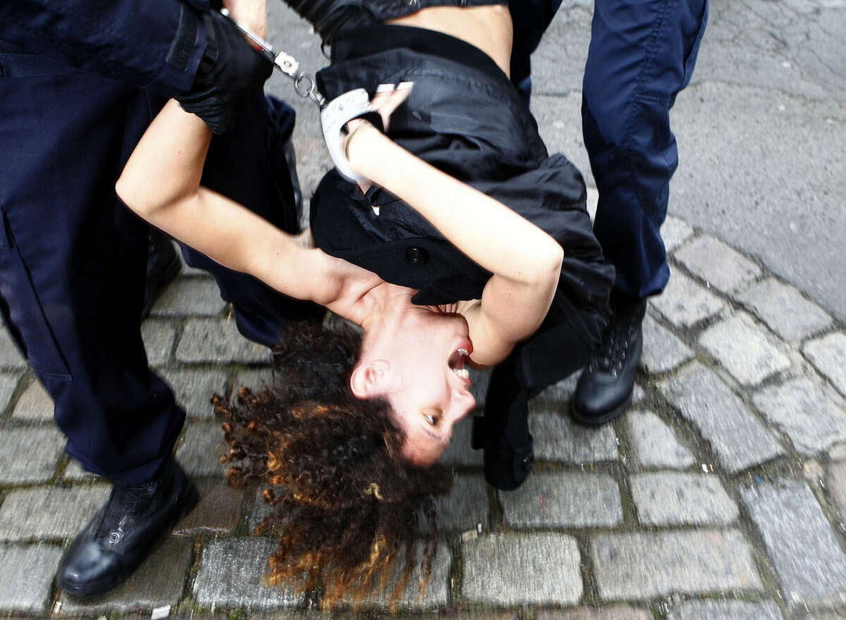 A Femen activist is taken away by police officers as she protests Tuesday, Feb. 10, 2015 in front of the Lille courthouse in Lille, northern France, where Dominique Strauss-Kahn goes on trial for sex charges in France. The former head of the International Monetary Fund, whose career went down in flames amid accusations of sexually assaulting a hotel maid in New York, is facing similarly shocking charges in France: aggravated pimping and involvement in a prostitution ring operating out of luxury hotels. (AP Photo/Michel Spingler)