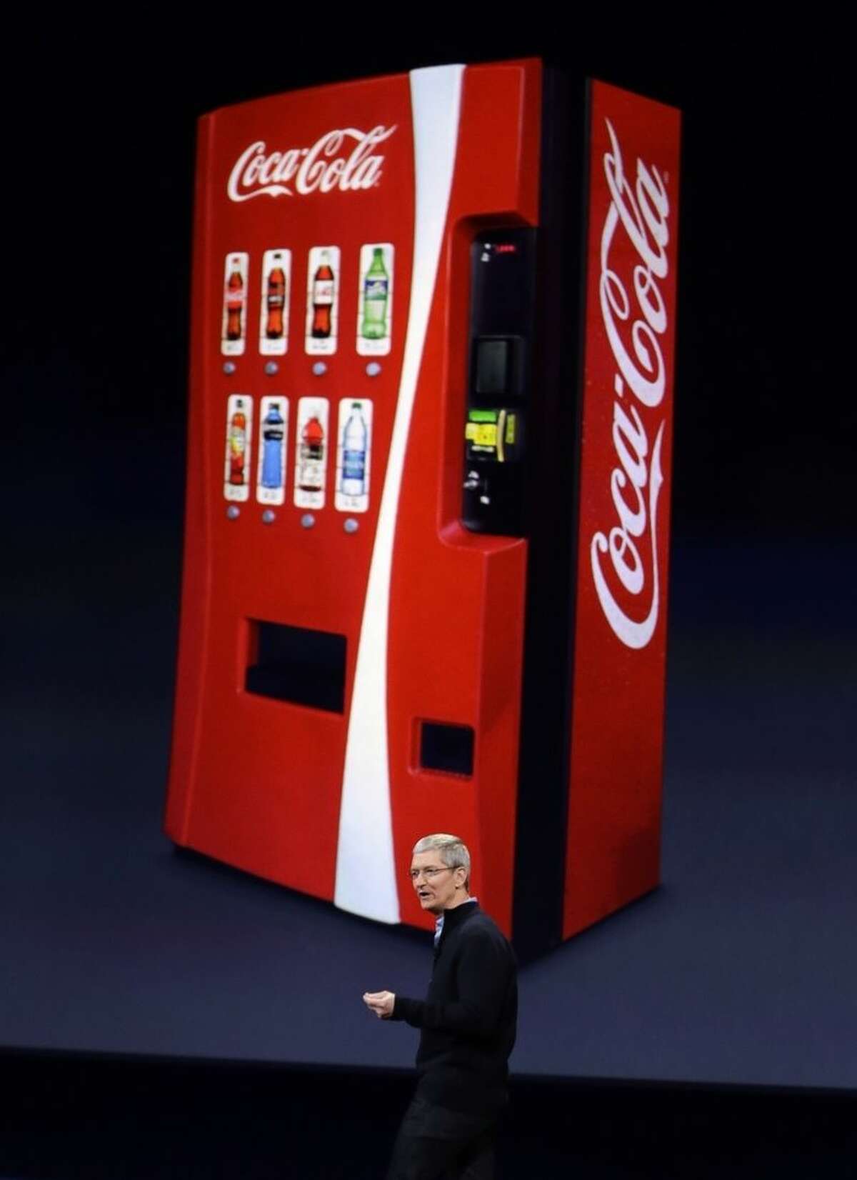 Apple CEO Tim Cook talks about using Apple Pay with Coca-Cola vending machines, during an Apple event on Monday, March 9, 2015, in San Francisco. (AP Photo/Eric Risberg)