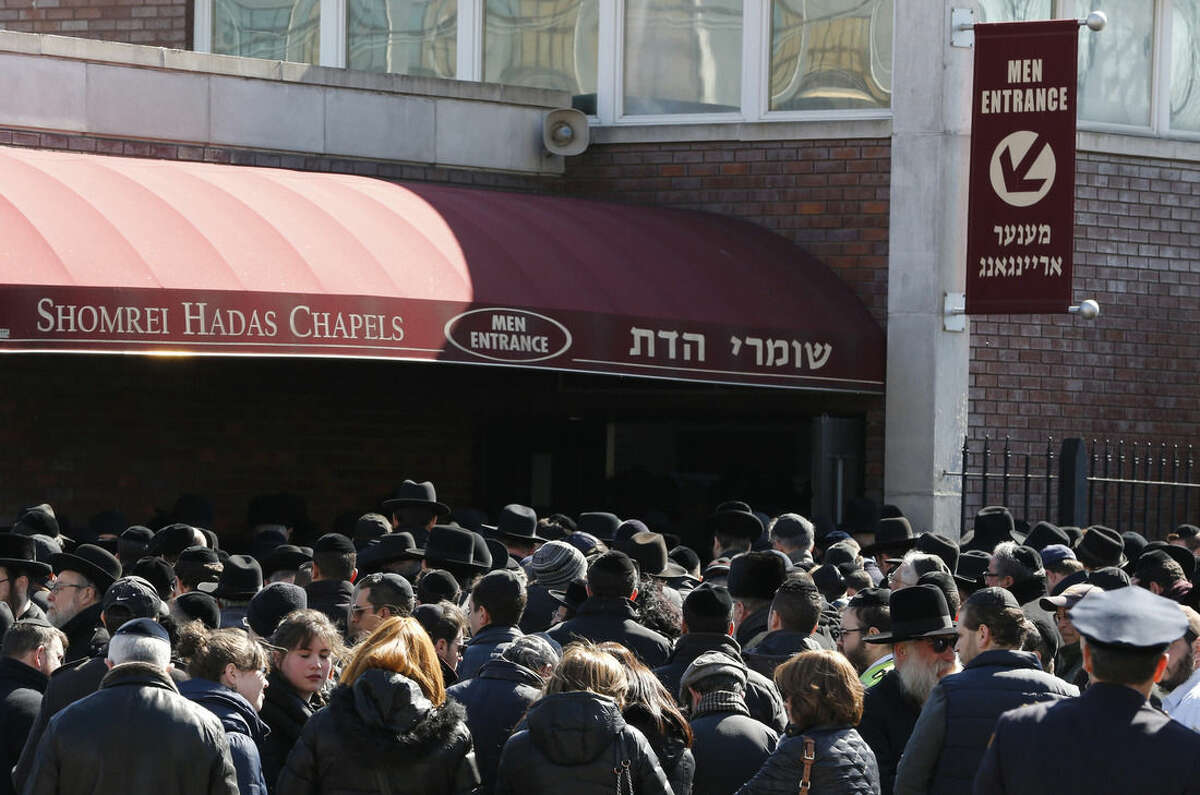 Mourners gather outside of Shomrei Hadas Chapels before a funeral service for the seven siblings killed in a house fire, Sunday, March 22, 2015, in the Brooklyn borough of New York. The siblings, ages 5 to 16, died early Saturday when flames engulfed the Sassoon family home in the Midwood neighborhood of Brooklyn. Investigators believe a hot plate left on a kitchen counter set off the fire that trapped the children and badly injured their mother and another sibling. (AP Photo/Julio Cortez)