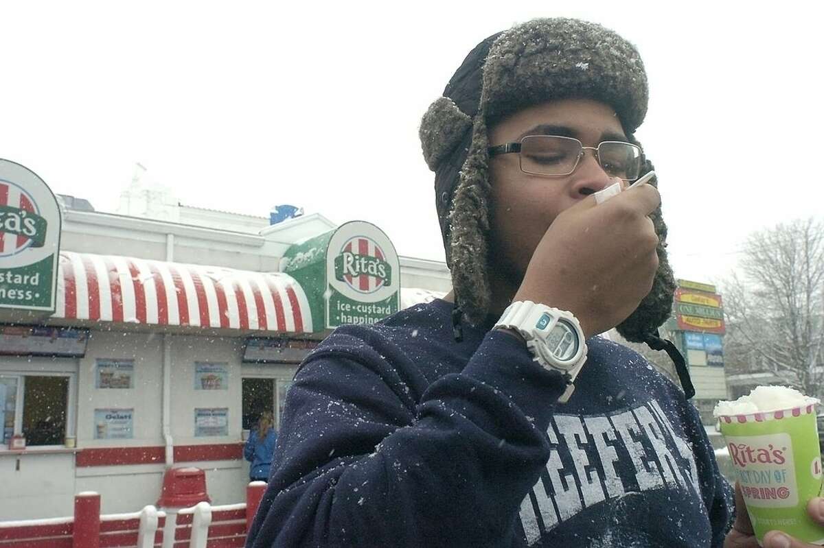 Austin Cooper takes a scoop of flavored ice during a snowstorm at Rita's in Kingston, Pa., Friday March 20, 2015. On the first day of Spring each year Rita's offers a free cup of the flavored ice to customers. (AP Photo/The Citizens' Voice, Mark Moran) MANDATORY CREDIT