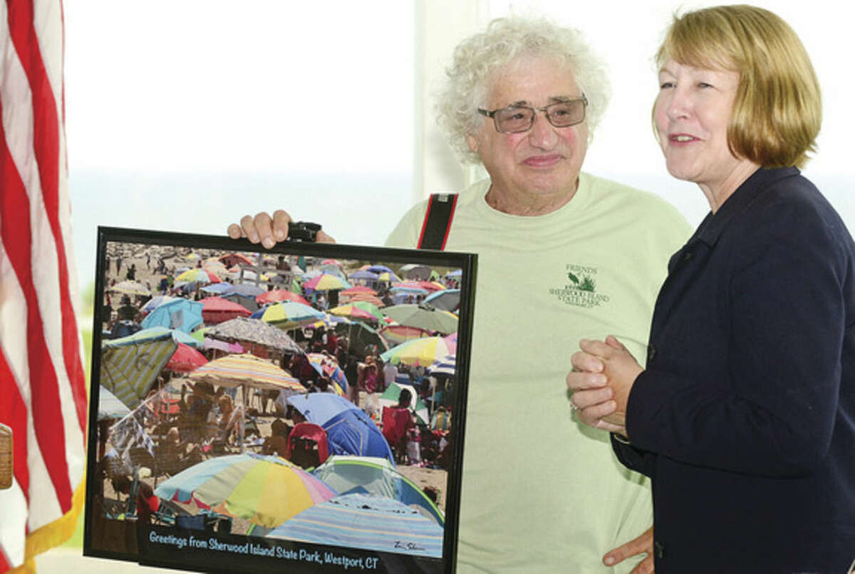 Hour photo / Erik Trautmann Renown Westport photographer Larry Silver presidents a limited edtion photograph to CT DEEP Deputy Commsioner Susan Whalen during a ceremony for the newly renovated Sherwood Island State Park Pavillion Tuesday afternoon.