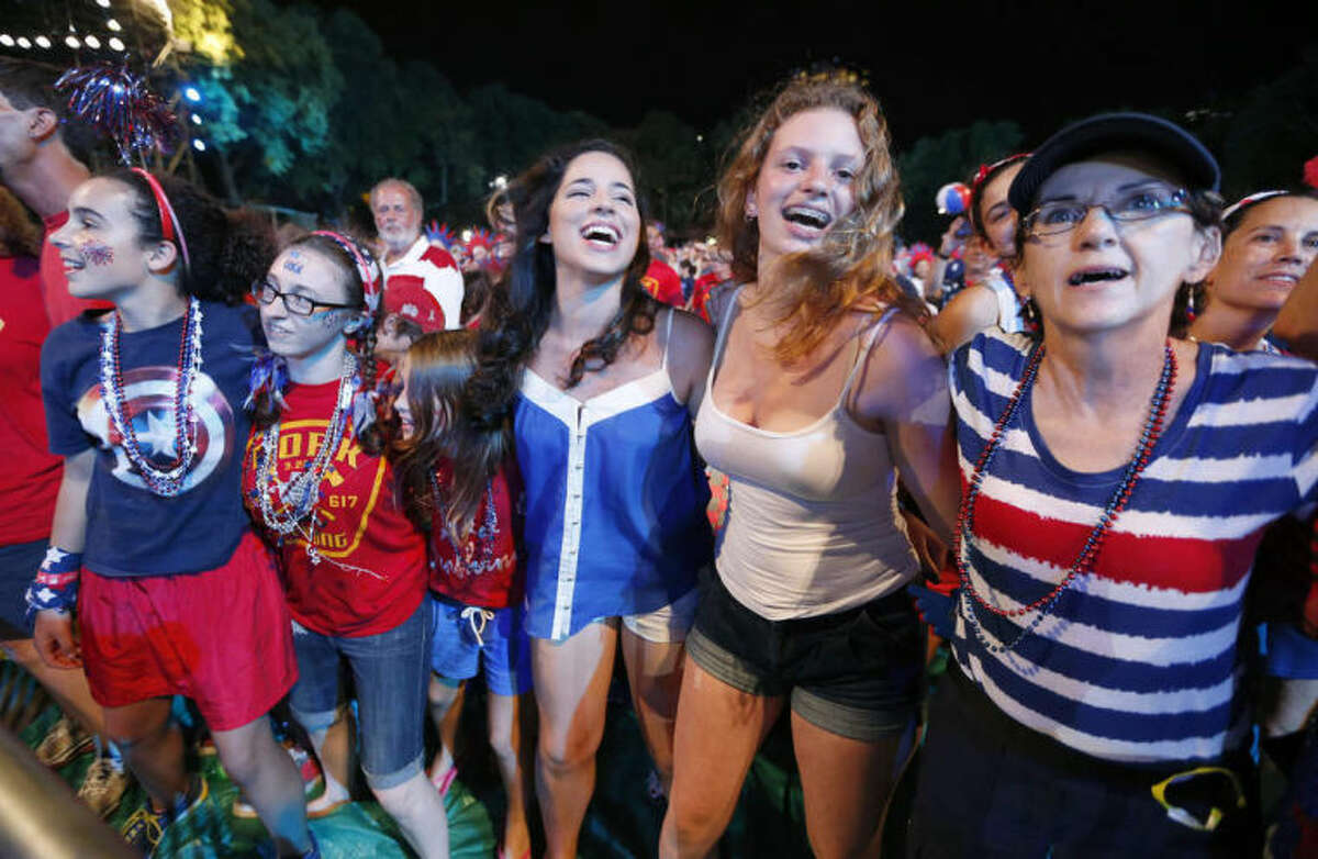 People dance to the Beach Boys during a concert at the Hatch Shell on the Esplanade in Boston, Thursday, July 3, 2014. The annual Boston Pops Fourth of July concert and fireworks show was moved up a day because of potential heavy rain ahead of Hurricane Arthur. (AP Photo/Michael Dwyer)