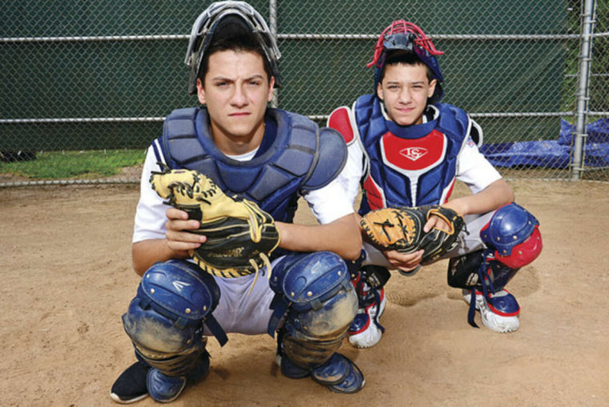 Hour photo/Erik Trautmann Hunter Dumas, left, who plays catcher on the Norwalk Babe Ruth 15-year-old all-star team, and his little brother, Jake Dumas, who also plays catcher for Norwalk's 12-year-old Little League All-Stars.