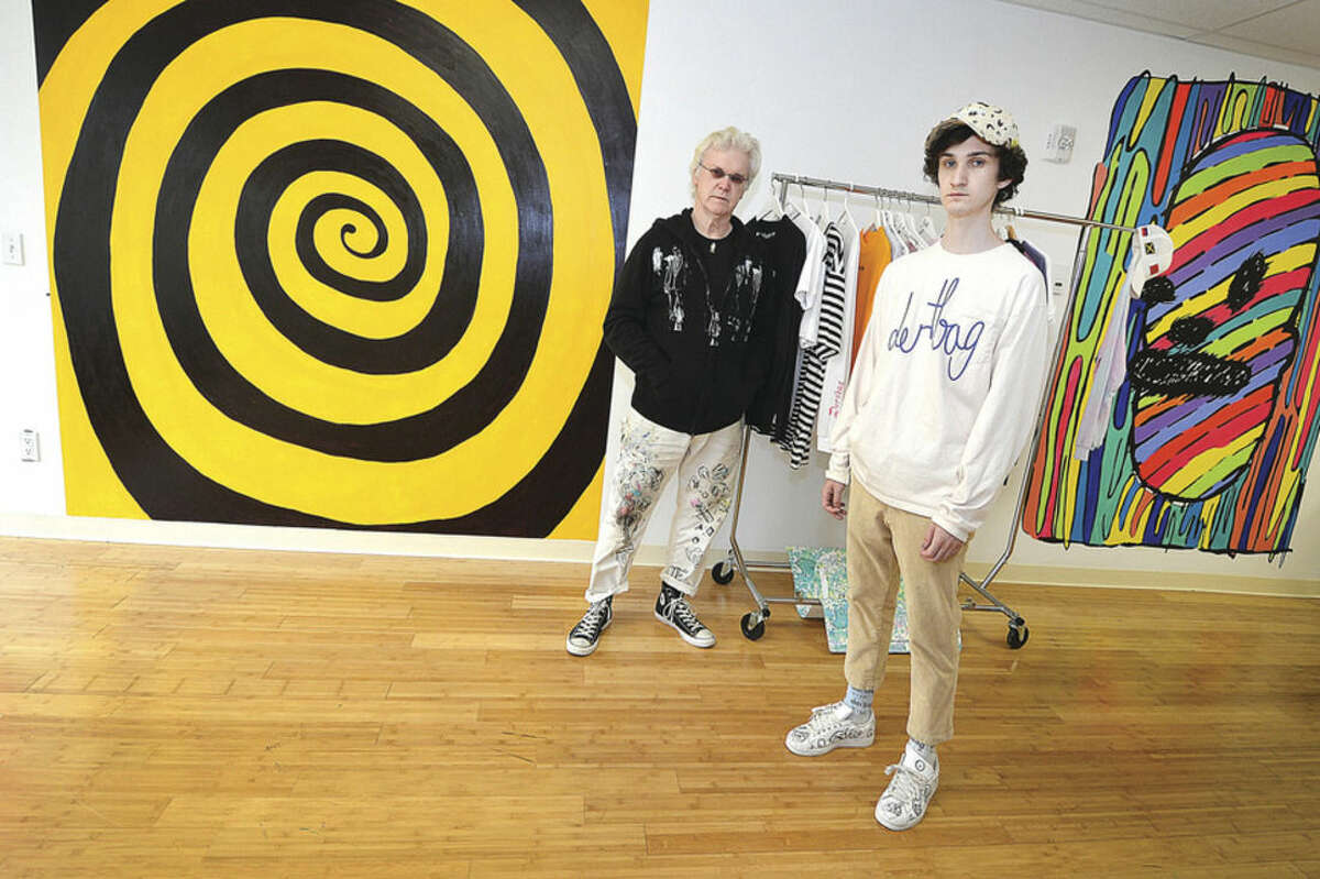 Hour Photo/Alex von Kleydorff Frank Foster Post and son Philip Post stand in front of the two murals Frank painted in his son's store, Dertbag, in Bridgeport's Arcade shops.