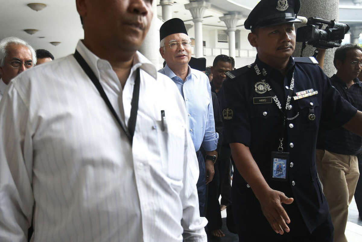 Malaysian Prime Minister Najib Razak, center, arrives at the Kuala Lumpur International Airport Mosque for Friday prayers where a special prayer was offered for the missing Malaysia Airlines flight MH370, Friday, March 14, 2014 in Sepang, Malaysia. Vietnam says it has downgraded but not stopped its search for the missing jetliner in the South China Sea and has been asked by Malaysian authorities to consider sending planes and ships to the Strait of Malacca. The statement Friday is a sign that the focus of the search effort is switching to the west of Malaysia, to the strait and further west into the Indian Ocean. (AP Photo/Wong Maye-E)
