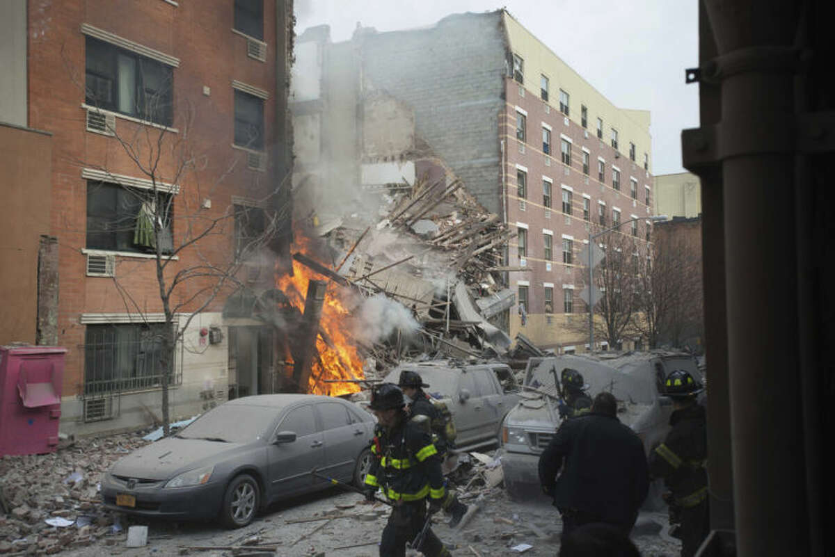 Firefighters work the scene of an explosion that leveled two apartment buildings in the East Harlem neighborhood of New York, Wednesday, March 12, 2014. Con Edison spokesman Bob McGee says a resident from a building adjacent to the two that collapsed reported that he smelled gas inside his apartment, but thought the odor could be coming from outside. (AP Photo/Jeremy Sailing)