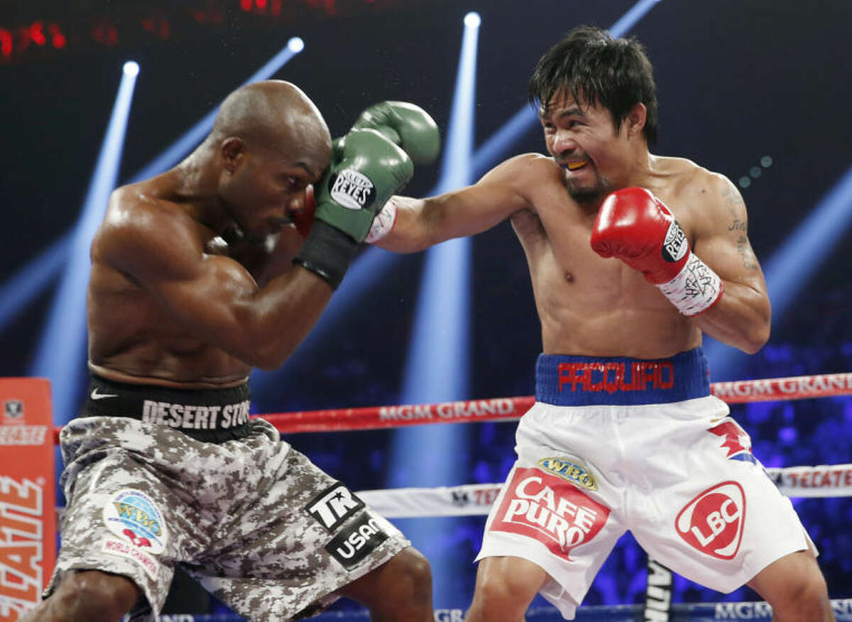 Manny Pacquiao, right, of the Philippines, throws a right at the head of Timothy Bradley during the WBO welterweight title boxing fight Saturday, April 12, 2014, in Las Vegas. (AP Photo/Eric Jamison)