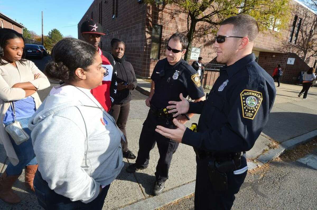 Hour Photo/Alex von Kleydorff   NEON employees speak with officers of the Norwalk Police Department who were relaying information from NEON officials about why late paychecks were bouncing. Acting CEO/President Chiquita Stephenson was "not in the building," people were told.