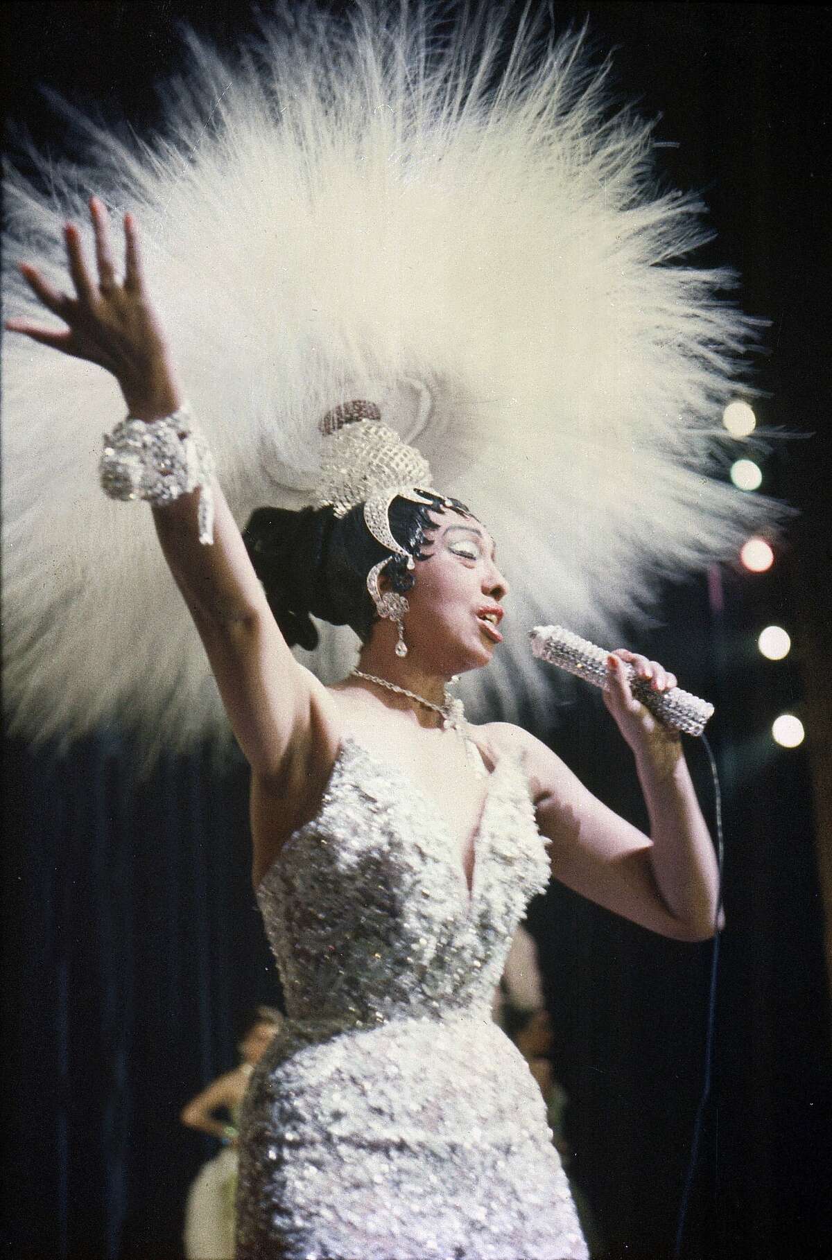 Josephine Baker holds a rhinestone-studded microphone as she performs during her show "Paris, mes Amours" at the Olympia Music Hall in Paris, France, on May 27, 1957.