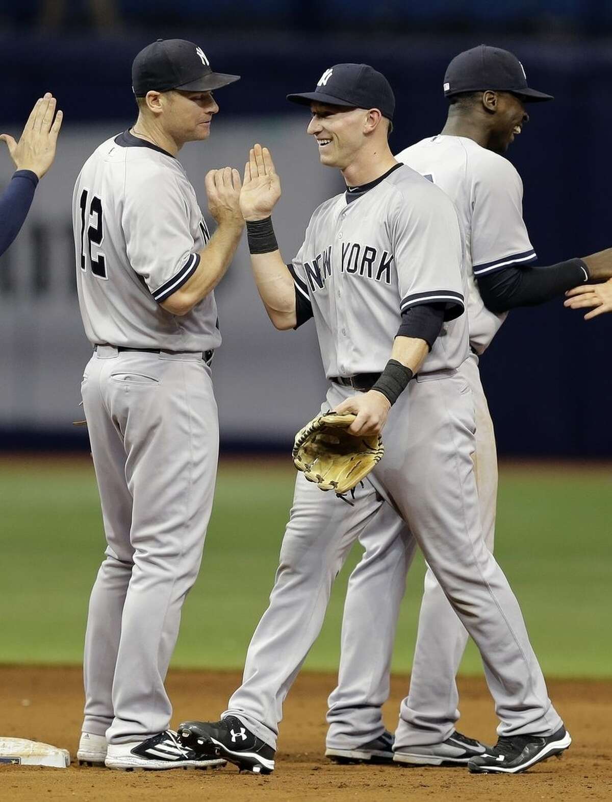 New York Yankees' Slade Heathcott, center, celebrates with teammates, including Chase Headley, left, and Didi Gregorius, right, after the Yankees defeated the Tampa Bay Rays 4-1 during a baseball game Monday, Sept. 14, 2015, in St. Petersburg, Fla. Heathcott had a three-run home run in the win. (AP Photo/Chris O'Meara)