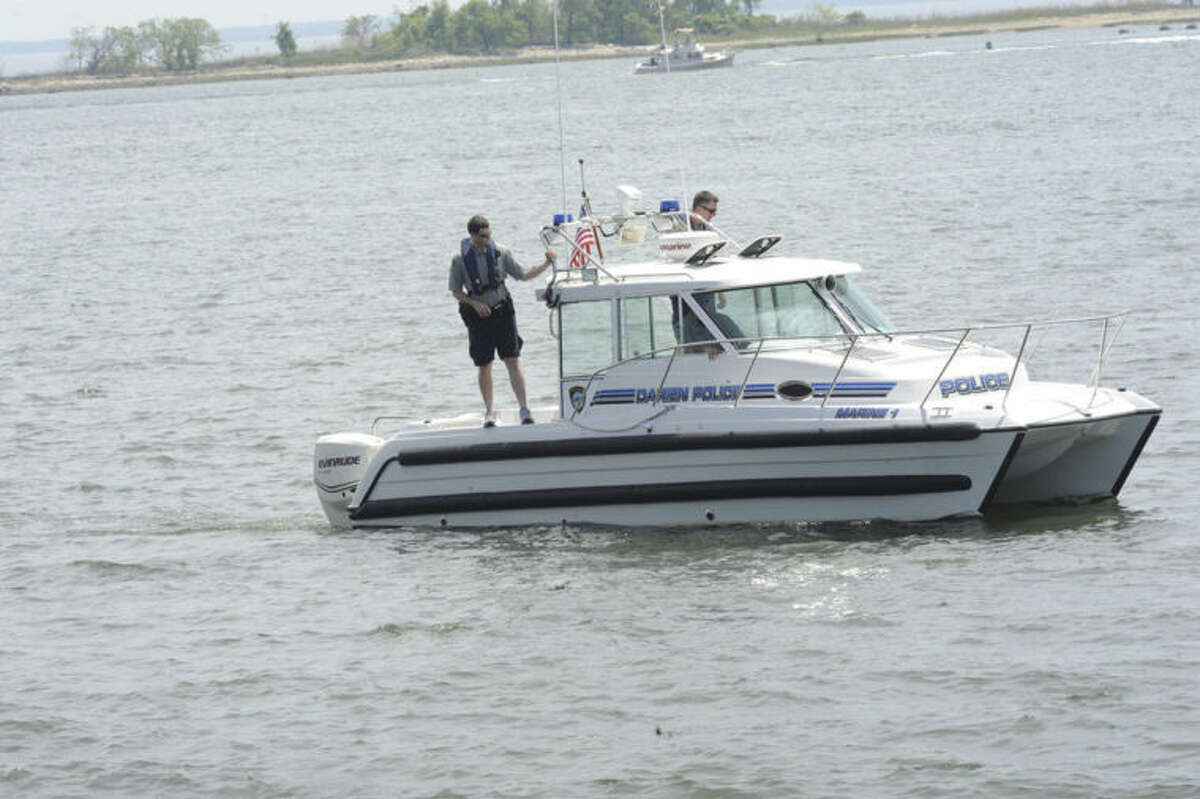 Darien police one of many in the search for a member of a turned over boat missing off the shore at Calf Pasture Beach in Norwalk. Hour photo/Matthew Vinci