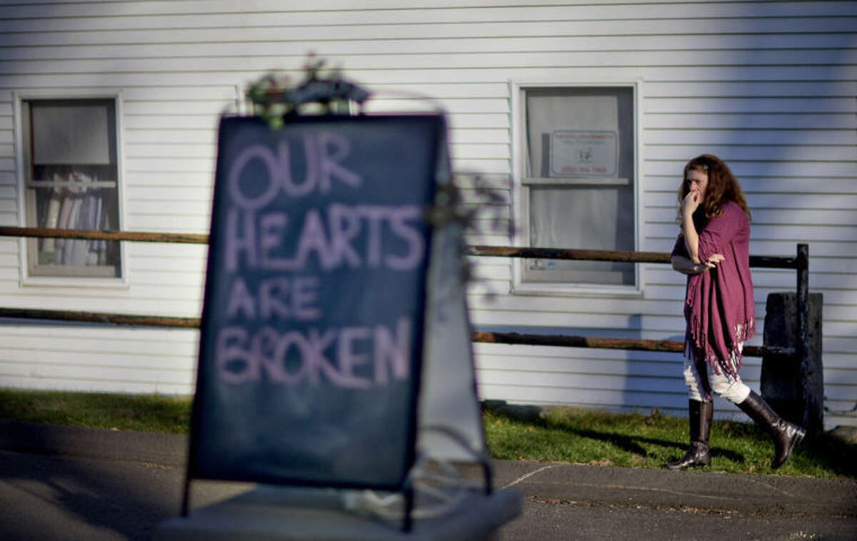 FILE - In this Dec. 15, 2012 file photo, shop owner Tamara Doherty paces outside her store just down the road from Sandy Hook Elementary School in Newtown, Conn. Although still relatively rare, there?•s been no real reduction in the number of school shootings since security was beefed up around the country with measures such as safety drills and the hiring of police officers. (AP Photo/David Goldman, File)