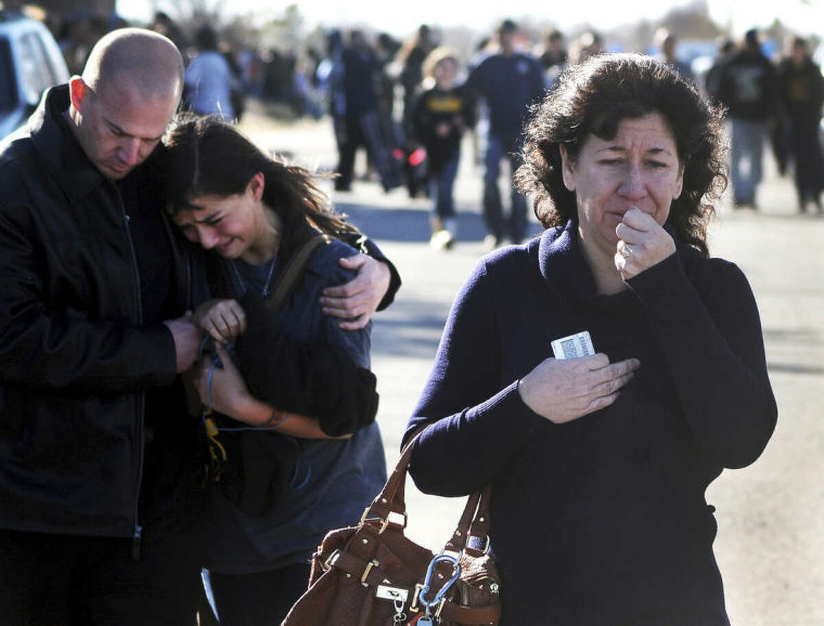 FILE - In this Jan. 14, 2014 file photo, a woman waits at a staging ground area where families are being reunited with Berrendo Middle School students after a shooting at the school in Roswell, N.M. Although still relatively rare, there?s been no real reduction in the number of school shootings since security was beefed up around the country with measures such as safety drills and the hiring of police officers, after the rampage at Connecticut's Sandy Hook Elementary School in December 2012. (AP Photo/Roswell Daily Record, Mark Wilson, File)