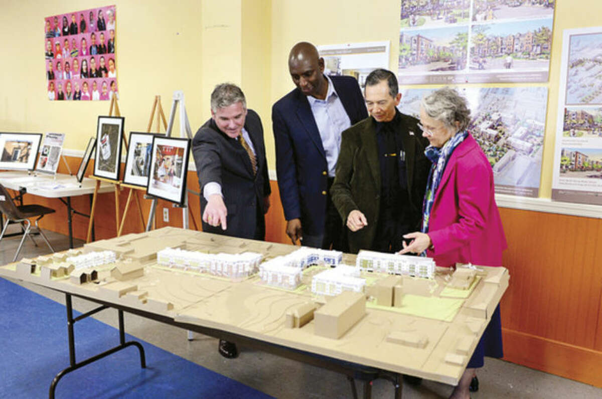 Hour photo / Erik Trautmann From left to right, Tim Sheehan, Patrick Lee, Cesar Ramirez, and Candace Mayer look over a model of the proposed Washington Village development during a meeting with the U.S. Department of Housing and Urban Development Thursday.