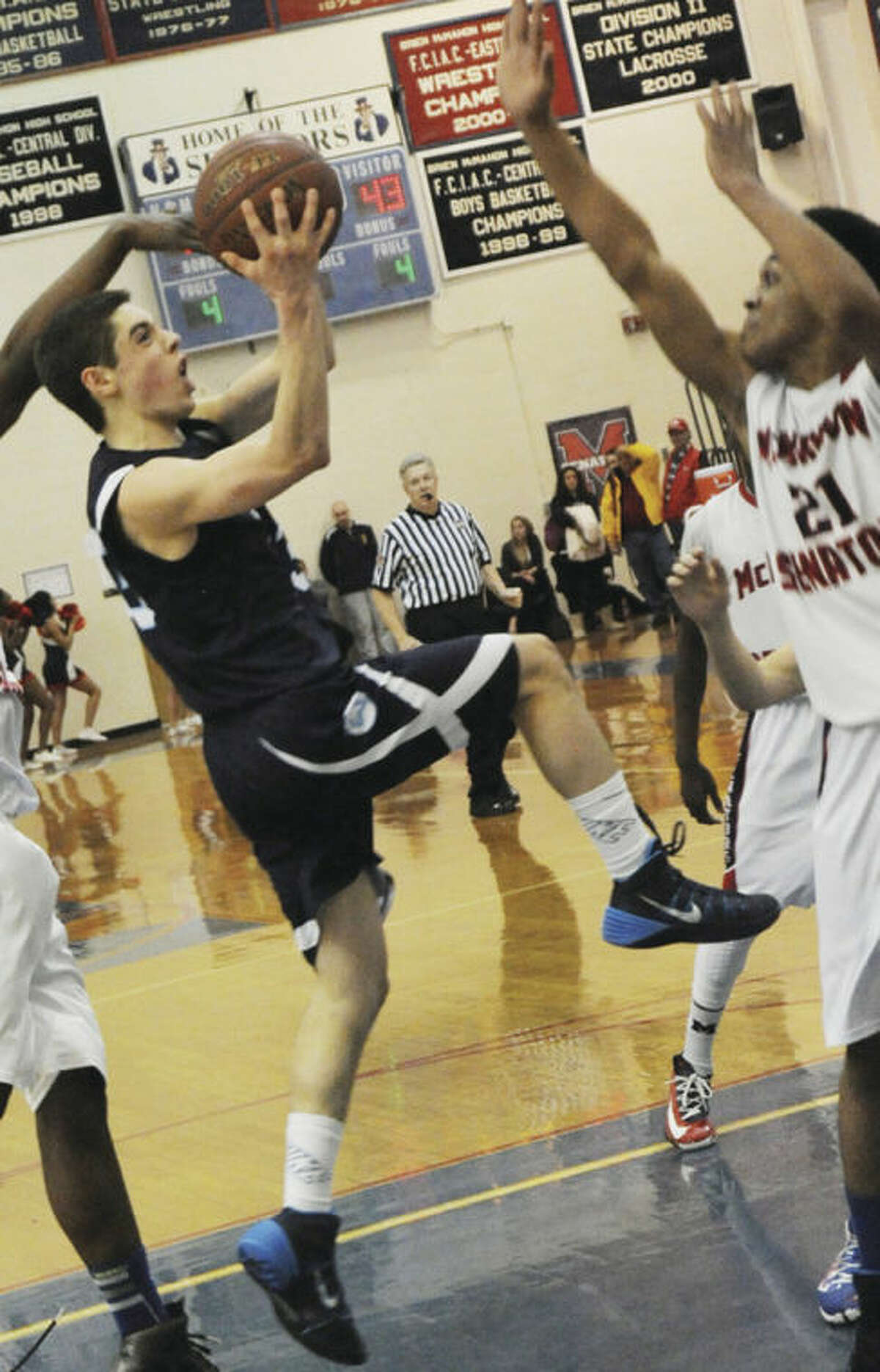 Hour photo/Matthew Vinci Wilton's Matt Shifrin, left, goes up for a shot over Timothy Hinton Jr. of Brien McMahon during Tuesday night's game.