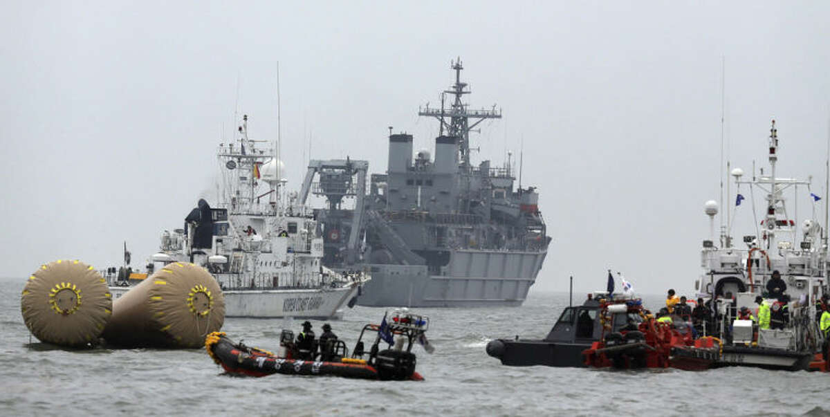 South Korean rescue team members try to search missing passengers of the sunken ferry Sewol near buoys which were installed to mark the area in the water off the southern coast near Jindo, South Korea, Saturday, April 19, 2014. The captain of the sunken South Korean ferry was arrested Saturday on suspicion of negligence and abandoning people in need, as investigators looked into whether his evacuation order came too late to save lives. Two crew members were also arrested, a prosecutor said. (AP Photo/Yonhap) Korea Out