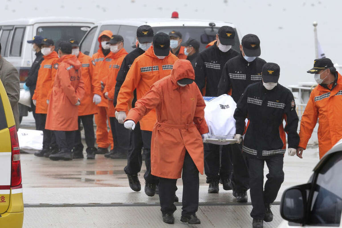 Rescue workers carry the body of a passenger aboard The Sewol ferry which sank in the water off the southern coast, at a port in Jindo, South Korea, Friday, April 18, 2014. Fresh questions arose about whether quicker action by the captain of a doomed ferry could have saved lives, even as rescuers scrambled to find hundreds of passengers still missing Friday and feared dead. (AP Photo/Yonhap) KOREA OUT