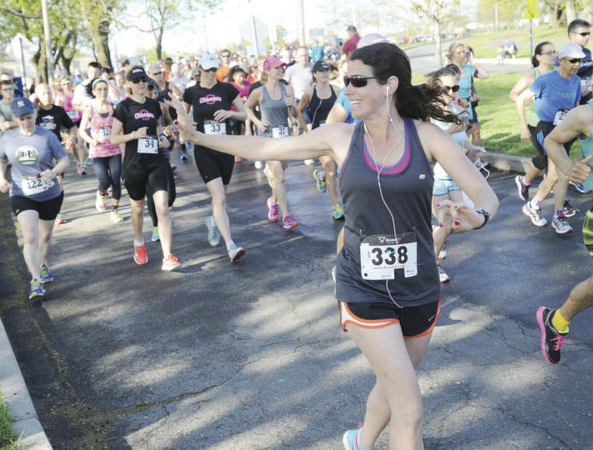 Jennifer Walker waves to her family, husband Joseph and daughters Sofia and Isabelle Sunday at the annual Mothers Day 10 K race at Calf Pasture Beach. Hour photo/Matthew Vinci