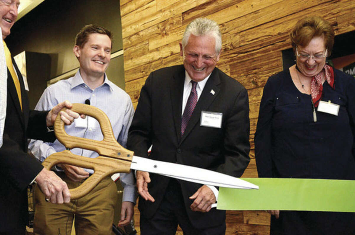 President and CEO of Cannondale Sports Peter Woods, Norwalk mayor Harry Rilling, and Lynne Ward look on as Wilton First Selectman Bill Brennan cuts the ribbon during the opening of Cannondale's global headquarters Friday at i.Park on the Norwalk-Wilton line.