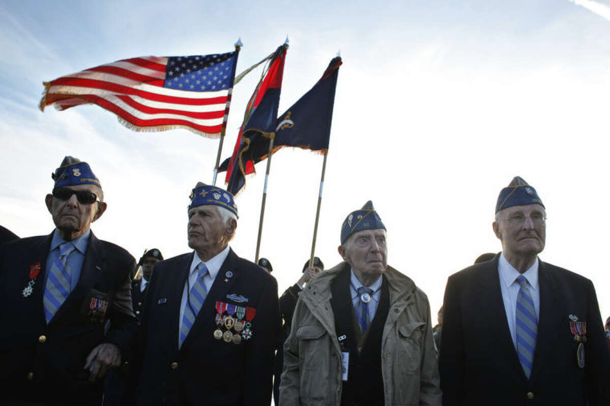 From left, World War II veterans of the U.S. 29th Infantry Division, Hal Baumgarter, 90 from Pennsylvania, Steve Melnikoff, 94, from Rhode Island, Don McCarthy, 90 from Maryland, and Morley Piper, 90, from Massachusetts, attend a D-Day commemoration, on Omaha Beach, western France , Friday June 6, 2014. Veterans and Normandy residents are paying tribute to the thousands who gave their lives in the D-Day invasion of Nazi-occupied France 70 years ago. World leaders and dignitaries including President Barack Obama and Queen Elizabeth II will gather to honor the more than 150,000 American, British, Canadian and other Allied D-Day troops who risked and gave their lives to defeat Adolf Hitler's Third Reich. (AP Photo/Thibault Camus)