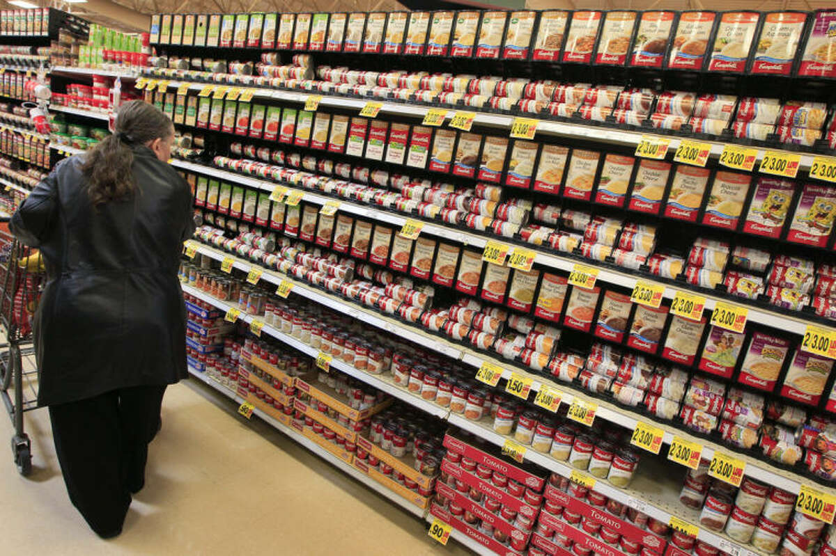 FILE - This Feb. 7, 2012 file photo shows a shopper walking down the canned soup aisle at a grocery store in Cincinnati. Food companies and restaurants could soon face government pressure to make their foods less salty _ a long-awaited federal effort to try and prevent thousands of deaths each year from heart disease and stroke. (AP Photo/Al Behrman, File)
