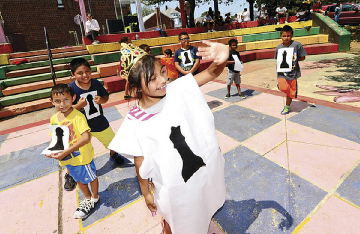 Hour photo / Erik Trautmann Carver Foundation Summer campers including Gisel Aguilar as the Black Queen participate in a game of human chess during the Friends of Ryan Park Summer Camper Awards celebration at the Park Friday afternoon. The Carver Foundation runs summer programs for more than 600 Norwalk children.