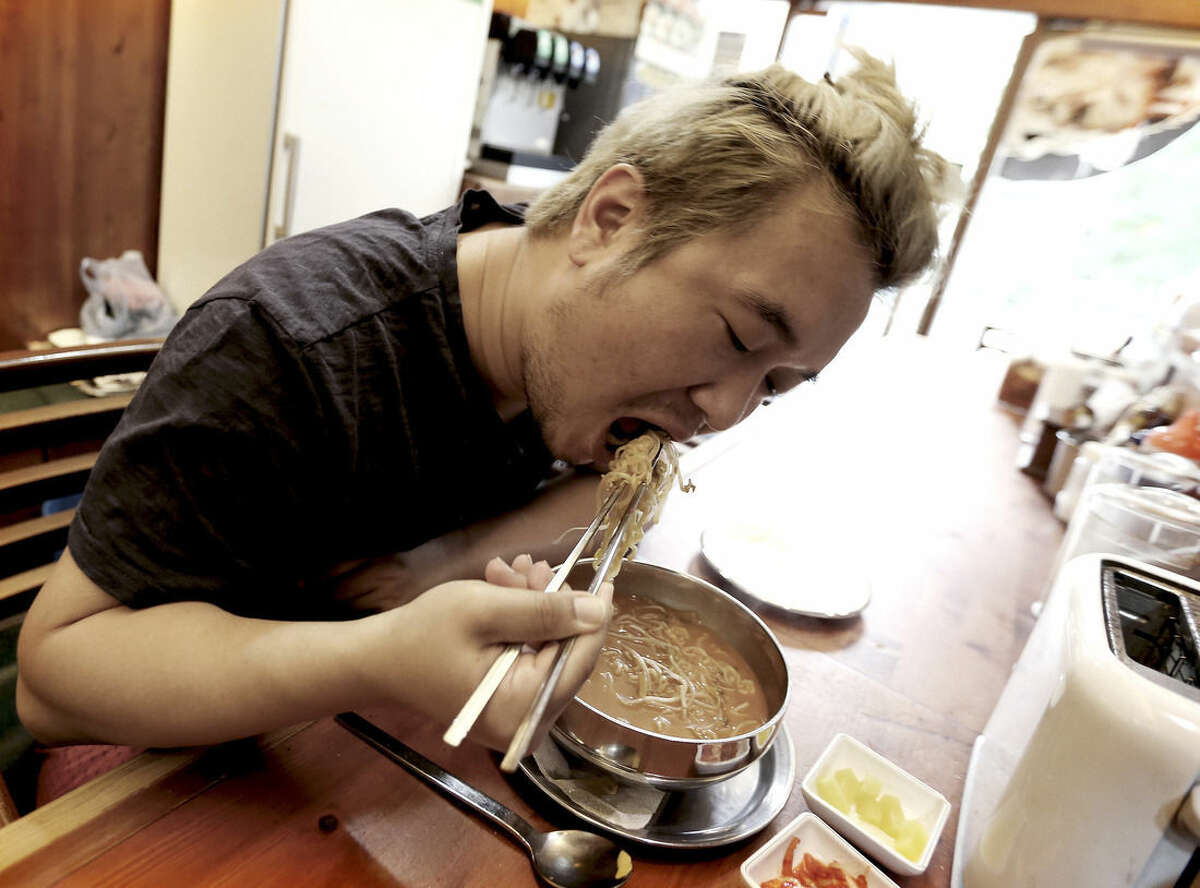 In this Aug. 19. 2014 photo, Han Seung-youn, 36, eats "ramyeon" instant noodle at a Ramyeon restaurant in Seoul, South Korea. Instant noodles are an essential, even passionate, part of life for many in South Korea and other Asian countries. Hence the emotional heartburn caused by a Baylor Heart and Vascular Hospital study in the United States that found excessive consumption of instant noodles by South Koreans was associated with risks for diabetes, heart disease or stroke. The study has provoked feelings of wounded pride, mild guilt, stubborn resistance, even nationalism among South Koreans, who eat more instant noodles per capita than anyone in the world. (AP Photo/Ahn Young-joon )