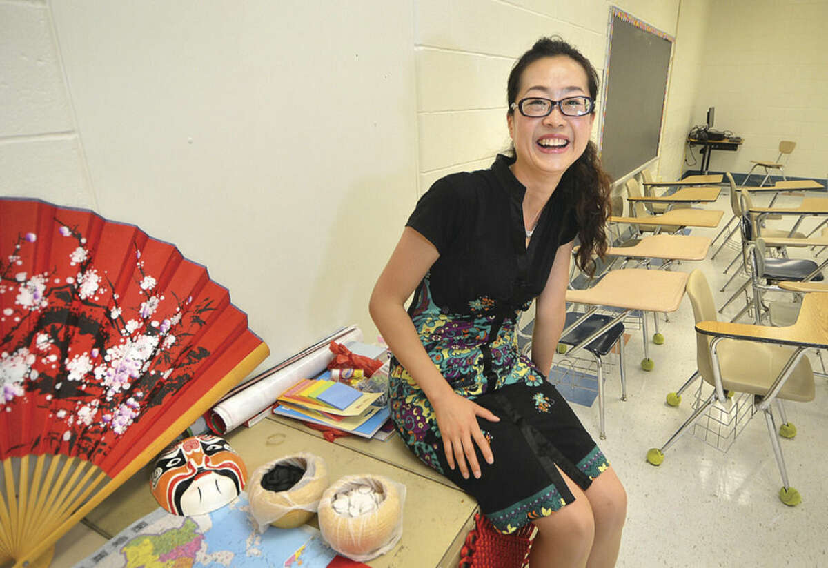 Hour Photo/Alex von Kleydorff Teacher Wei Wei from China is happy to start making this classroom at Roton Middle School hers for the next school year.