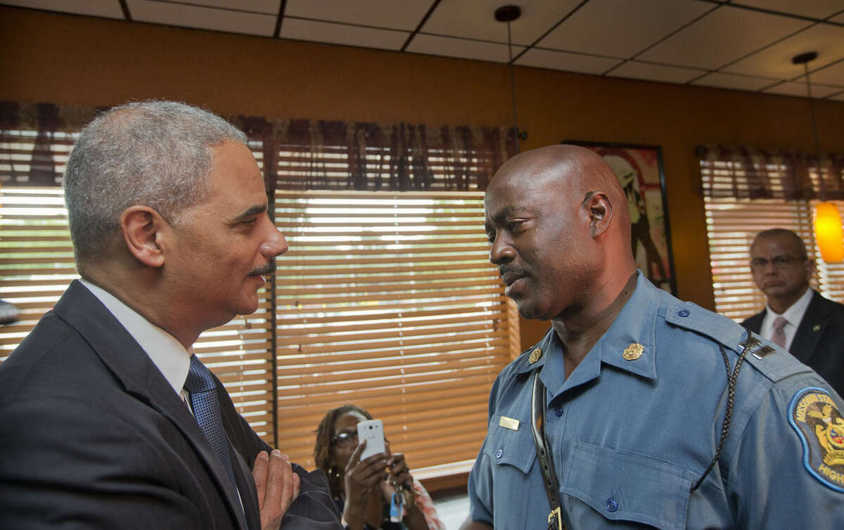 Attorney General Eric Holder speaks with Capt. Ron Johnson of the Missouri State Highway Patrol at Drake's Place Restaurant, Wednesday, Aug. 20, 2014, in Ferguson, Mo. Holder arrived in Missouri on Wednesday, a small group of protesters gathered outside the building where a grand jury could begin hearing evidence to determine whether a Ferguson police officer who shot 18-year-old Michael Brown should be charged in his death. (AP Photo/Pablo Martinez Monsivais, Pool)
