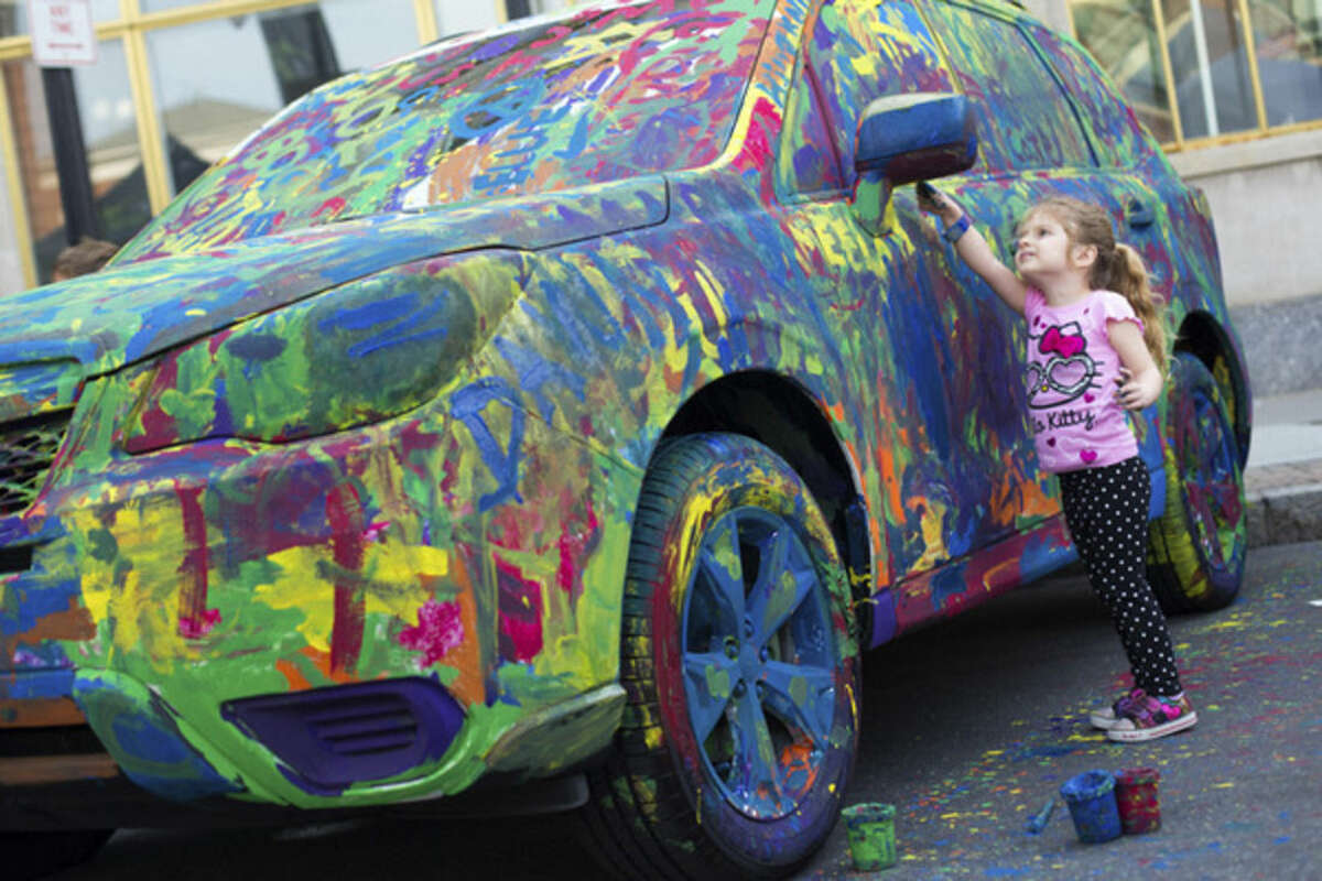 Above, Gracie Kerins, 3, of Norwalk, paints a car provided by Garavel Subaru at the 39th Annual SoNo Arts Festival Saturday afternoon. Lower left, the Funky Dawgz Brass Band performs on Washington Street at the festival. Lower right, Virginia Atkinson purchases some jewelry from Lise Weller of OMI by Lise. The celebration was first held in 1974 and kicked off a Renaissance for the South Norwalk business area, which was slated for demolition, according to Norwalk Mayor Harry Rilling. The festival hosts a diverse group of artists, musicians, dancers, children's entertainers and crafters in SoNo.