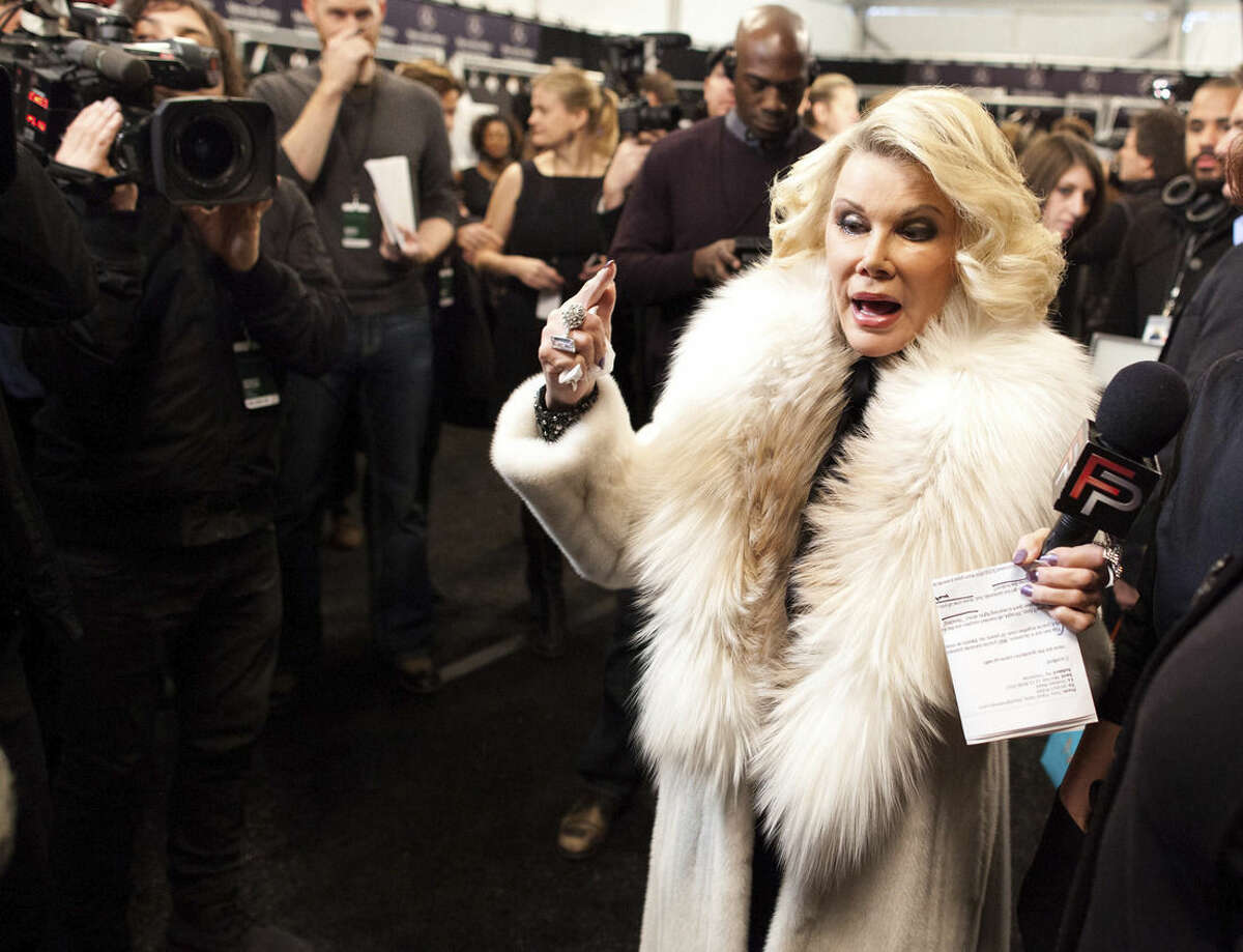FILE - In this Feb. 14, 2012 file photo, Joan Rivers tours backstage with her camera crew for E!'s "Fashion Police," before the Badgley Mischka show during Fashion Week in New York. In the intense, high-stakes world of fashion, Joan Rivers helped change the game. Rivers, the raucous, acid-tongued comedian who crashed the male-dominated realm of late-night talk shows and turned Hollywood red carpets into danger zones for badly dressed celebrities, died Thursday, Sept. 4, 2014. She was 81. Rivers was hospitalized Aug. 28, after going into cardiac arrest at a doctor's office. (AP Photo/John Minchillo, File)