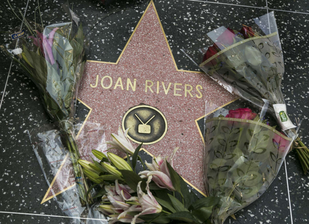 Flowers surround Joan Rivers' star on the Hollywood Walk of Fame in Los Angeles Thursday, Sept. 4, 2014. Rivers, the raucous, acid-tongued comedian who crashed the male-dominated realm of late-night talk shows and turned Hollywood red carpets into danger zones for badly dressed celebrities, died Thursday. She was 81. (AP Photo/Damian Dovarganes)