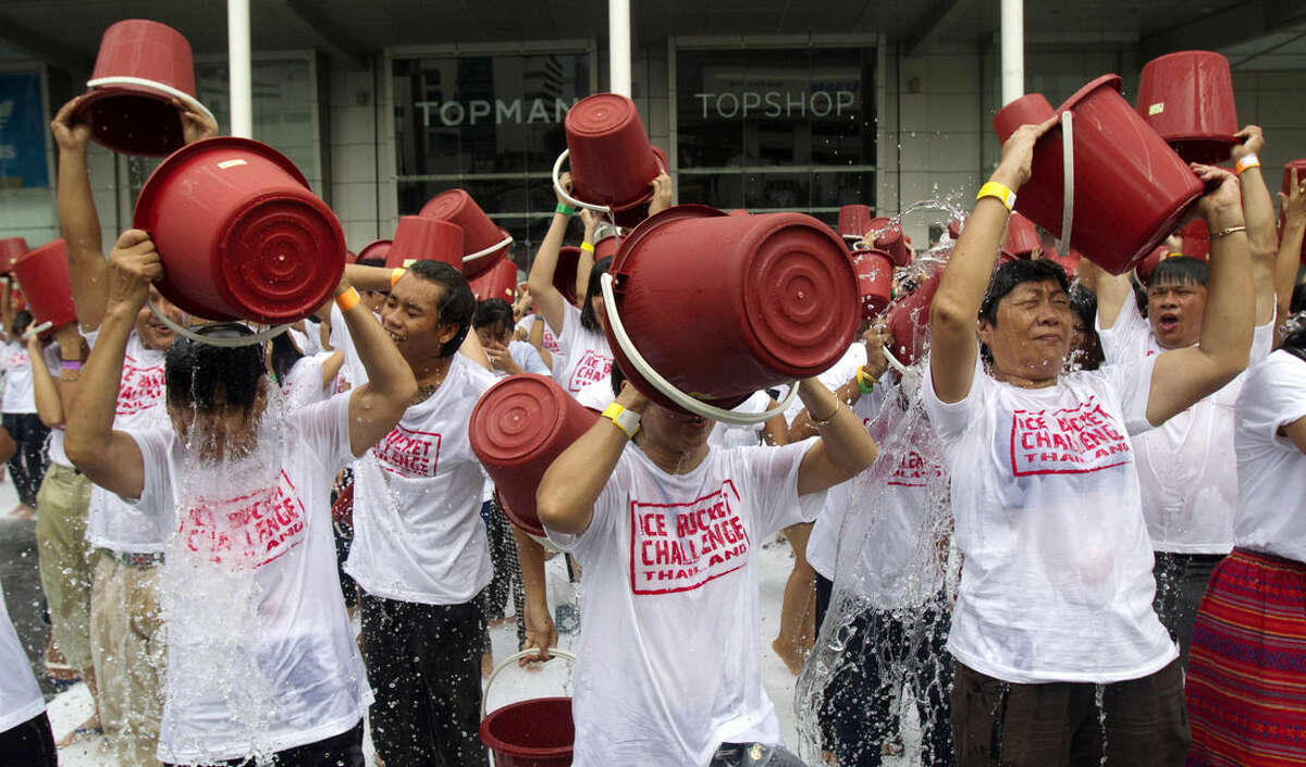 FILE - In this Friday, Aug. 22, 2014 file photo, people pour ice water over themselves during an "ice bucket challenge" fund raising event in Bangkok. About a thousand people turned out to raise money for the fight against ALS, or Lou Gehrig's Disease. (AP Photo/Sakchai Lalit)