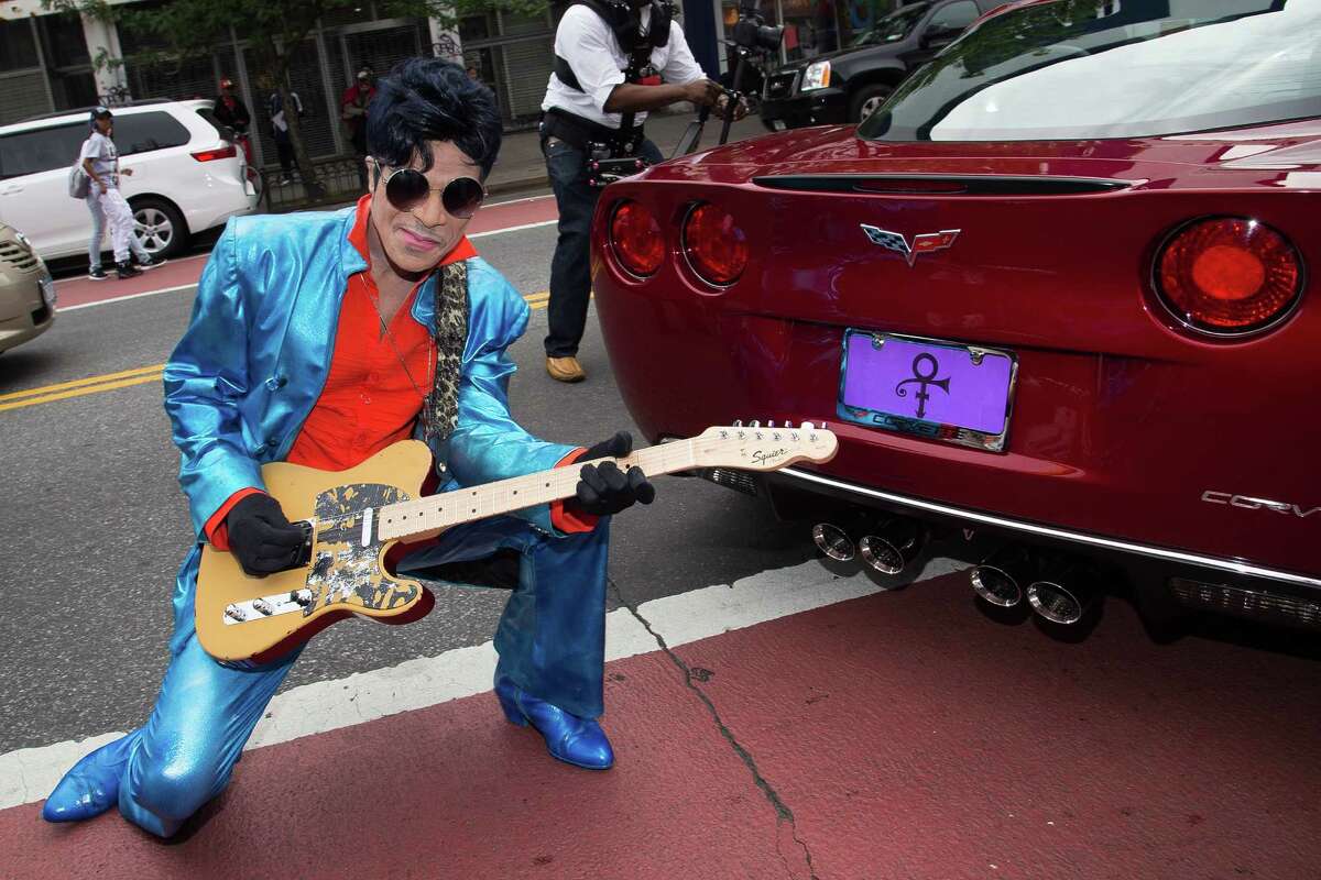 Prince impersonator C.P. Lacey poses with a red Corvette outside the Apollo Theater Walk of Fame induction ceremony honoring Prince on Monday, June 13, 2016, in New York. Prince died at his home on April 21, in suburban Minneapolis. He was 57. (Photo by Charles Sykes/Invision/AP) ORG XMIT: NYCS105