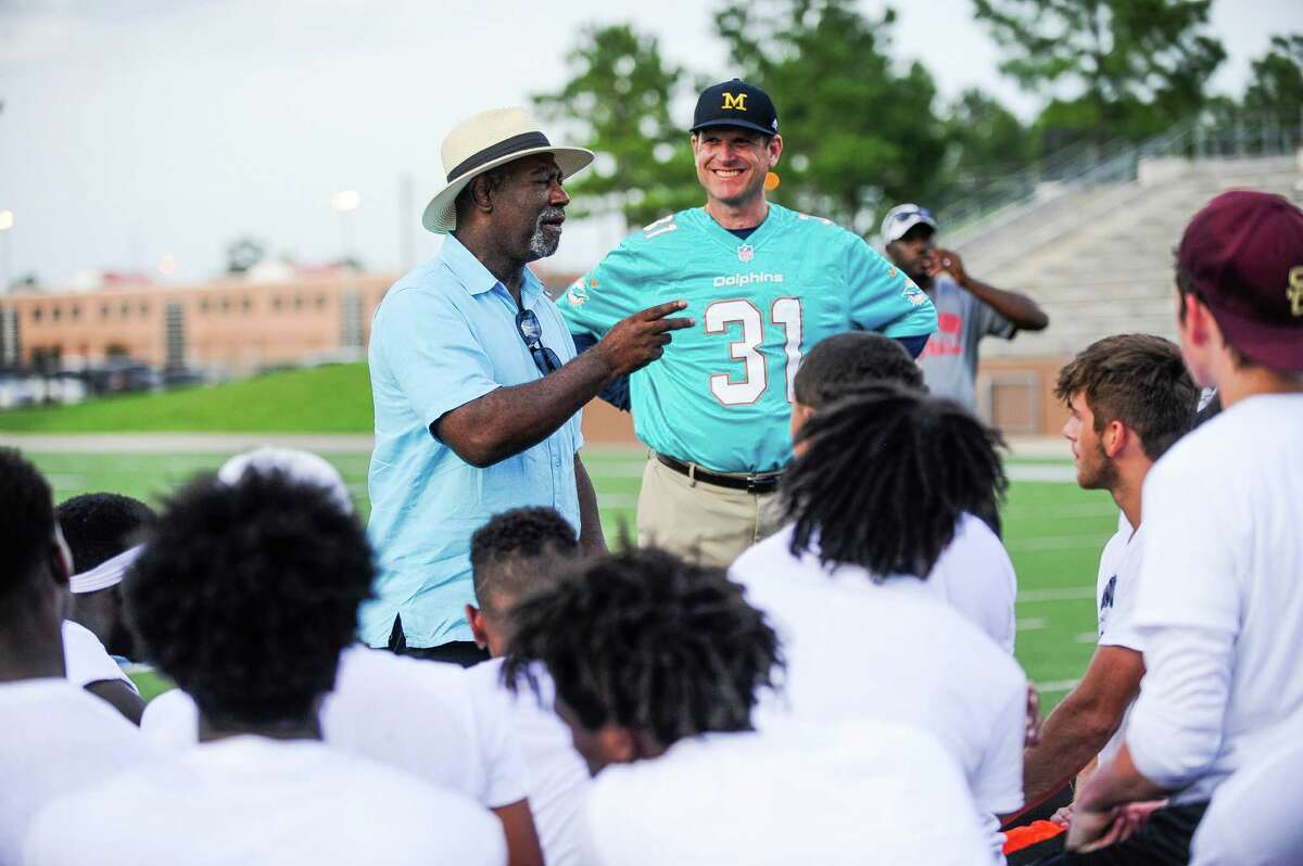Head football coach at The University of Michigan Jim Harbaugh listens as Michael Thomas, father to the Dolphin's player Michael Thomas, talks to the athletes at the East Houston Elite Football Showcase Monday, June 13, 2016. His son, who played high school football in Texas was coached by Jim Harbaugh at Stanford.