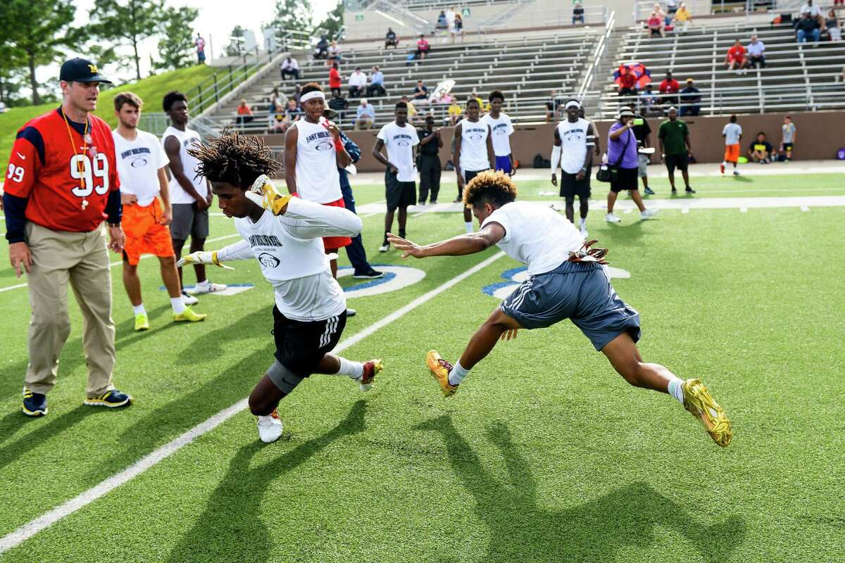 Michigan football coach, Jim Harbaugh, oversees one of the drills at the East Houston Elite Football Showcase at Galena Park ISD Stadium.
